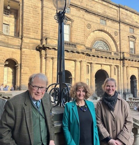 Three people standing outside Old College, Edinburgh